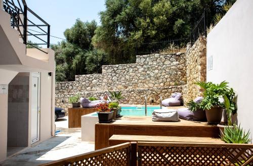 a backyard with a swimming pool and a stone wall at AZOGIRE Resort in Azoyirés