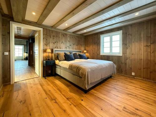 a bedroom with a bed in a room with wooden walls at Cabin With Panoramic View In Synnfjell in Nord Torpa