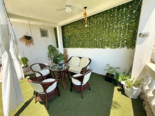 a patio with a table and chairs and a green wall at Apartmani Avanti Becici in Becici