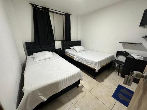 a hotel room with two beds and a window at Hotel Cañaveral Plaza 2 in Manizales