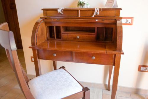een oud houten bureau met een stoel ernaast bij b&b La casa di Ely in Marcellinara