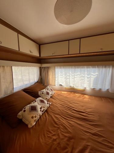 une chambre avec un lit avec deux oreillers dessus dans l'établissement Les Hulottes, à Le Vrétot