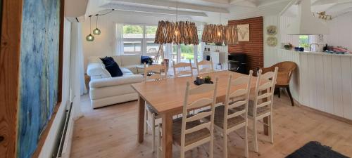 a kitchen and dining room with a table and chairs at Home Near Juelsminde By The Beach in Sønderby