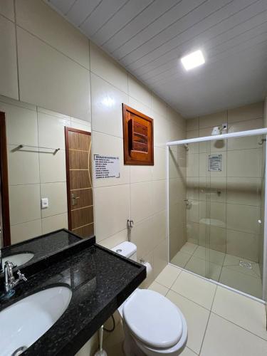 a bathroom with a toilet and a sink and a shower at Chalé Sossego Serrano in Mulungu