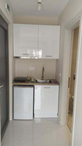 a kitchen with white cabinets and a sink at MeTime3 in Parga