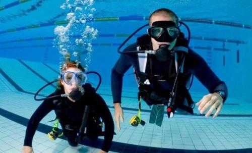 two people are in a swimming pool at The Hollywood Hostel - Free Breakfast Waffles - Early and Late Check OK! Women Rooms - Men Rooms - Long Term OK in Hallandale Beach