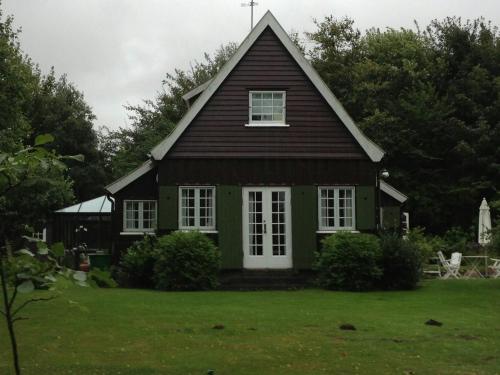 a green house with a gambrel roof at Wooden House From 1921 Near The Sea In Gilleleje in Gilleleje