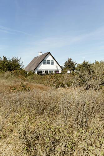 a house sitting on top of a grassy hill at Atmosphere Close To Water Surrounded By Pines in Hvide Sande