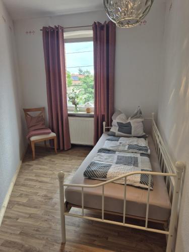 a bed in a room with a window and a bed sidx sidx sidx at Ferienhaus Bärbel Großes Ferienhaus nahe Quedlinburg in Ditfurt