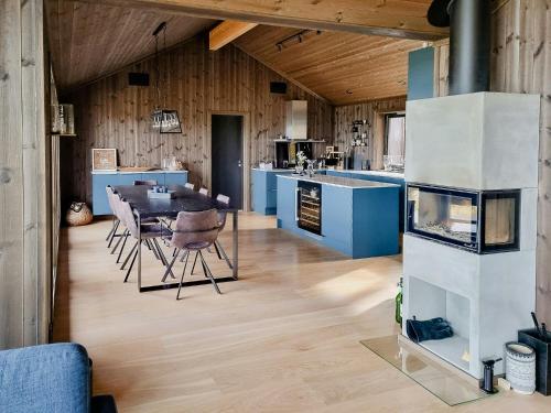 cocina con mesa de comedor y armarios azules en Luxury Mountain Home With View On Gaustablikk, en Rjukan