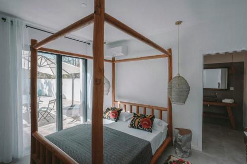 - une chambre avec un lit à baldaquin dans une maison dans l'établissement Elegance And Nature Design House In Corsica, à Taglio-Isolaccio