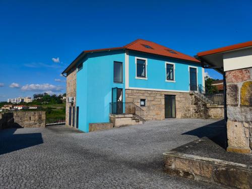 a blue house with a red roof at Casa Alamela in Penafiel