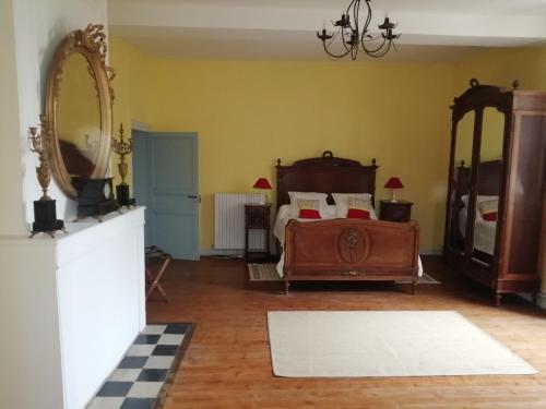 une chambre avec un lit et un grand miroir dans l'établissement Le Logis des Touches, à Villars-en-Pons