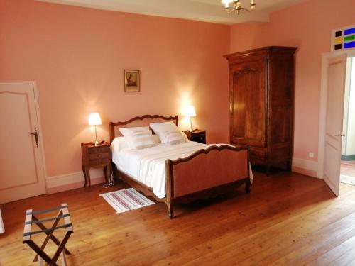 - une chambre avec un lit, une commode et deux lampes dans l'établissement Le Logis des Touches, à Villars-en-Pons