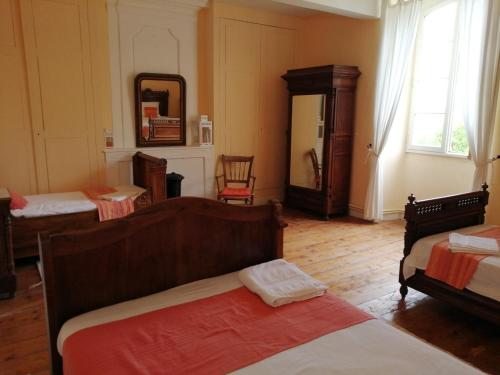Cette chambre comprend 2 lits et un miroir. dans l'établissement Le Logis des Touches, à Villars-en-Pons