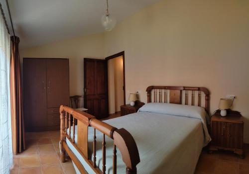 a bedroom with a bed with a wooden bed frame at Casa Rural María in Los Alagones