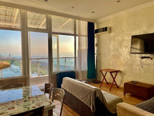 a living room with a view of the ocean at Batumi seaside Magnolia in Batumi