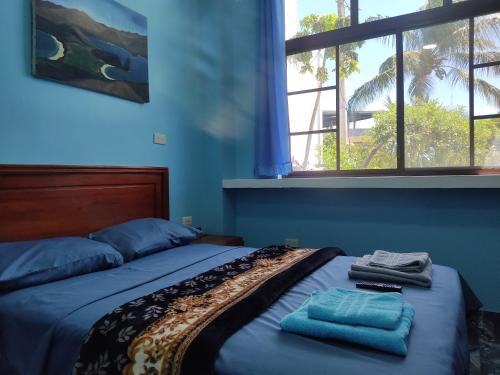 プエルト・バケリソ・モレノにあるCasa Cypress - Acogedor Departamento Vacacionalのベッドとタオル2枚のある寝室