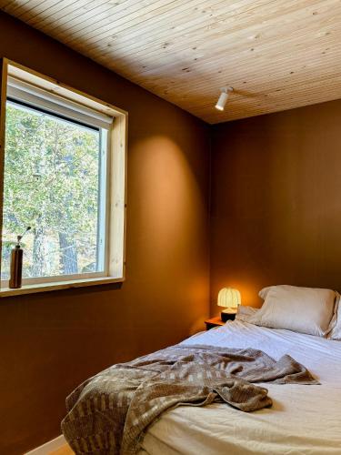 a bedroom with a bed and a window at Idyllic Island House With Pool in Svartsö