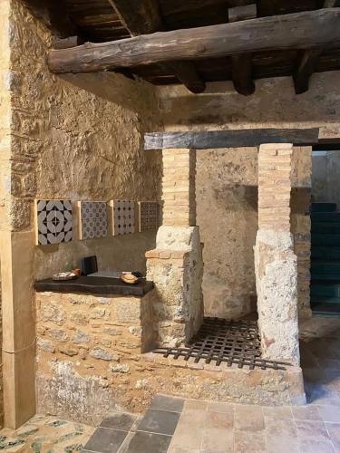 a stone building with a table on the side of it at La Locanda del Curato Rooms in Lentiscosa