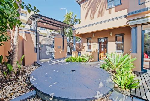 a patio in front of a house with a building at Albatross Guest House Bantry Bay in Cape Town