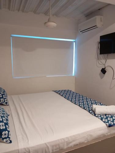 a white bed in a room with a window at Hotel Nativo Manzanillo in Cartagena de Indias