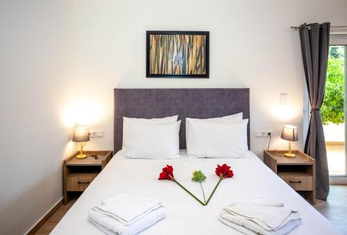 a bedroom with a bed with two red flowers on it at AZOGIRE Resort in Azoyirés
