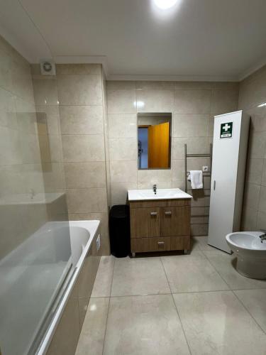 a bathroom with a tub and a sink and a toilet at Vila do Ilhéu in Vila Franca do Campo