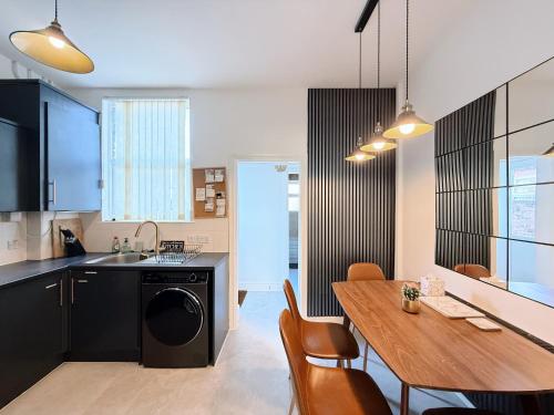 a kitchen and dining room with a wooden table and a dining room at Bee Stays - Pickmere House in Warrington