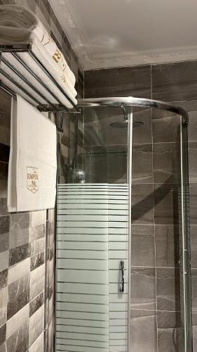 a shower with a glass door in a bathroom at Empire M in Kinshasa