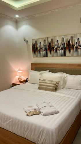 a white bed with a pair of shoes on it at Empire M in Kinshasa