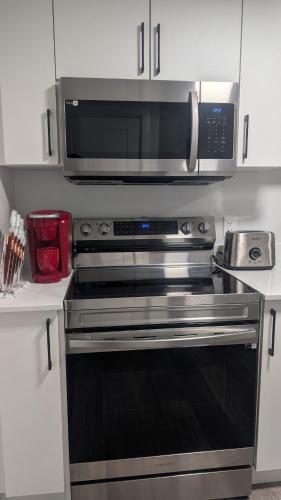 a kitchen with a microwave and a stove at Cozy Escape Guest Suite in Edmonton