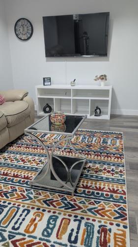 a living room with a coffee table and a tv at Cozy Escape Guest Suite in Edmonton