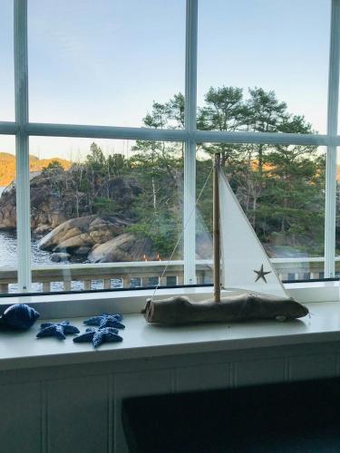 a toy sail boat sitting on a window sill at Explore Håøya Nature Reserve in Helgeroa
