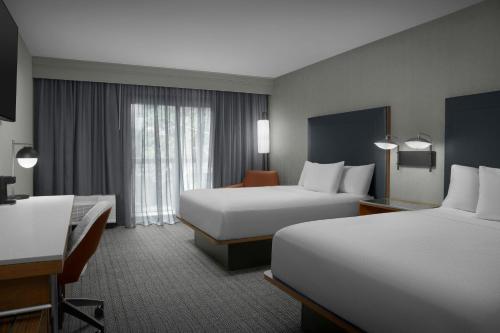 a hotel room with two beds and a desk at Courtyard Spokane Downtown at the Convention Center in Spokane