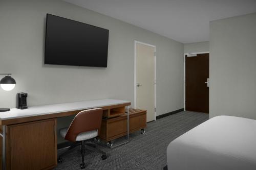 a hotel room with a desk and a bed and a television at Courtyard Spokane Downtown at the Convention Center in Spokane