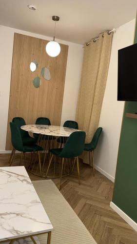 una sala da pranzo con tavolo e sedie verdi di MOON 25 a Nizza