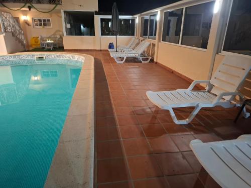 a patio with chairs and a swimming pool at Casa do Diniz in Travassos