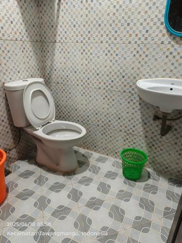 a bathroom with a toilet and a sink at Samara homestay in Mantaak