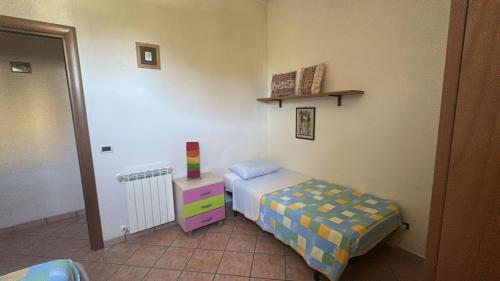 una piccola camera con un piccolo letto e un comò di Appartamento Franca a Capo dʼOrlando