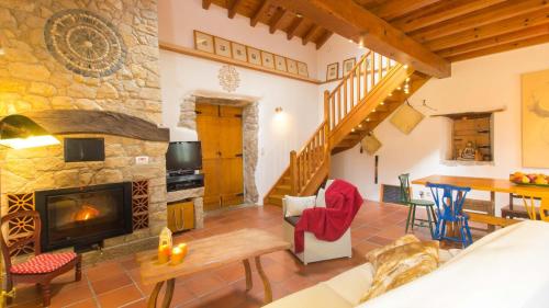 a living room with a stone fireplace and a table at Casa Raiz Guest House & Retiro in Ferreira do Zêzere