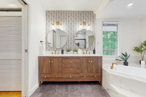 Un baño con una cómoda de madera y dos espejos. en Hatcher's Haven, en Sevierville