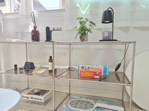 a glass shelf with books and other items on it at Golden Stay in Chuncheon
