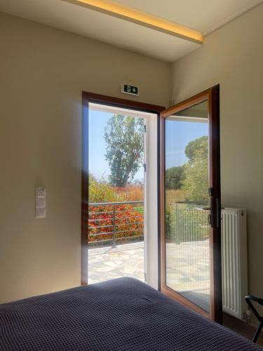 a bedroom with a bed and a sliding glass door at ISSA Thermi in Loutrópolis Thermís