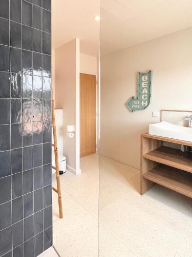 La salle de bains est pourvue d'un lavabo et d'une paroi en verre. dans l'établissement Somptueuse villa 9 chambres et sa piscine privé - 100 m de la plage, à La Couarde-sur-Mer