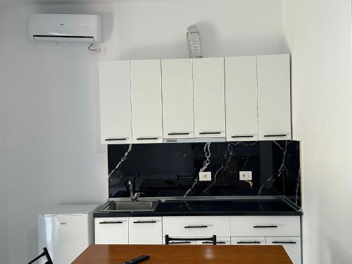 a kitchen with white cabinets and a sink at Villa Aliaj in Vlorë