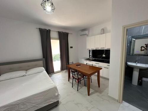 a bedroom with a bed and a table and a sink at Villa Aliaj in Vlorë