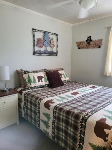 a bedroom with a bed with a checkered blanket at Castaways Cottage on Croton Pond #1 in Newaygo