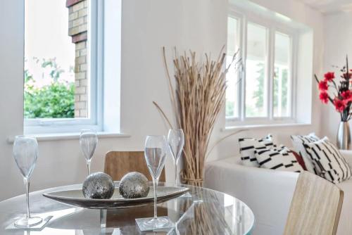 a dining room with a glass table with wine glasses at 2 Bed Flat, Dedicated workspace, Parking, 4KTV in London