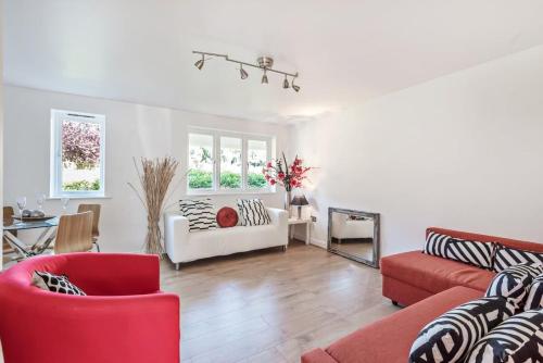 sala de estar con sillas rojas y sofá rojo en 2 Bed Flat, Dedicated workspace, Parking, 4KTV, en Londres